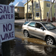 Two signs warn cars not to create a wake on a flooded street in Florida.